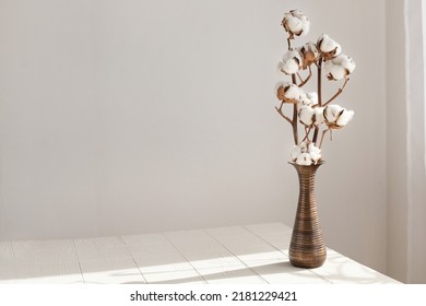 Cotton branch in a minimalist white interior in a vase on the table - Powered by Shutterstock