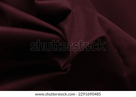 Cotton fabric of noble maroon color. Delicate draping and a smooth texture with a subtle matte sheen. background texture, pattern.