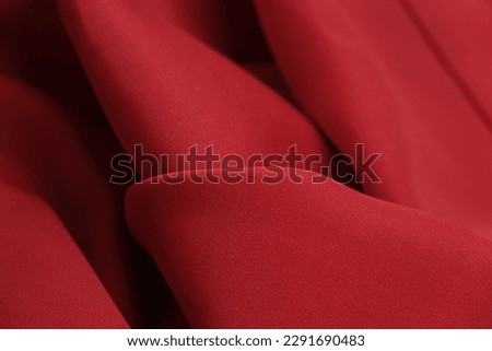 Cotton fabric of noble scarlet color. Delicate drape and smooth texture with a subtle matte sheen. background texture, pattern.