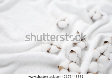 Cotton flowers on a white terry towel with copy space.
