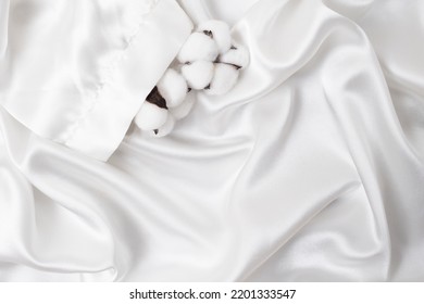 Cotton Flowers In A White Satin Robe Sleeve. Silky Smooth Product Mockup For Display. Flat Lay Close Up. . 