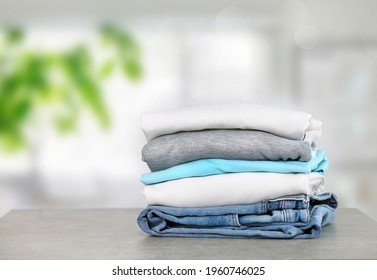 Cotton Folded Clothes On Table Indoors. Clean Apparel Stacked. Stack Of Clothing. Household.