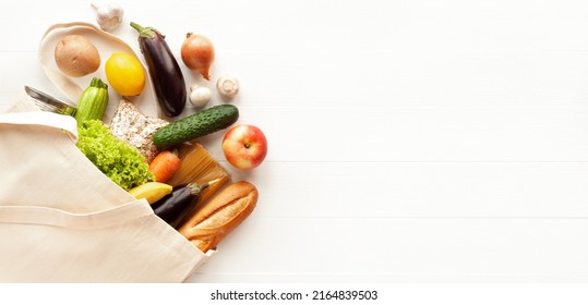 Cotton grocery tote bag with fresh vegetables, fruits, baguette and canned goods on white wooden background. Healthy food shopping, eco-friendly concept. Flat lay, copy space, banner. - Shutterstock ID 2164839503