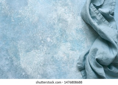 Cotton kitchen napkin or towel over light blue slate, stone or concrete table.Copy space background.