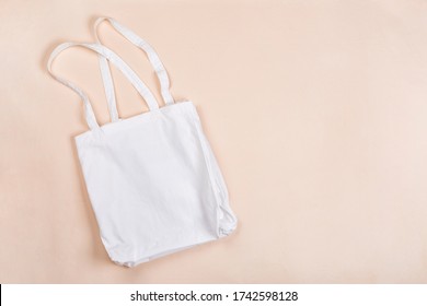 Cotton reusable bag on a beige canvas background. Eco-friendly concept. Flat lay, copy space - Powered by Shutterstock