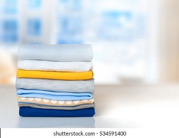 Cotton stack of colorful folded clothes on white table indoors empty space background.Household concept.Clean laundry pile. - Shutterstock ID 534591400
