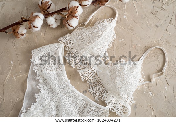 綿の縞模様のパンティと白いブラ コンクリートの背景に女性のランジェリー おしゃれな女性の下着のトップビュー 天然の柔らかい織物 の写真素材 今すぐ編集