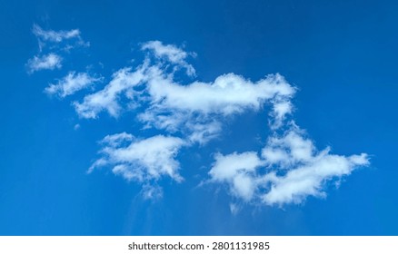 Cotton structure of lonely cloud moves freely across the blue sky. The gentle movement of an atmospheric front. A majestic swirling spectacle. A calm passage of dance.