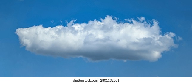 Cotton structure of lonely cloud moves freely across the blue sky. The gentle movement of an atmospheric front. A majestic swirling spectacle. A calm passage of dance.