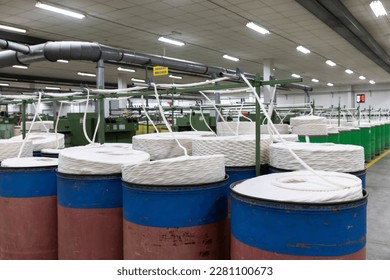 cotton yarn going through spinning process to produce a thinner yarn that can then be used to weave cotton sheets of fabric - Powered by Shutterstock