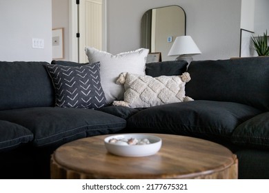 Couch With Decorative Throw Pillows Behind A Coffee Table With A Bowl Of Shells