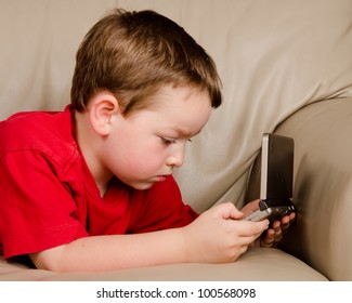 Couch Potato Concept Of Boy Playing Video Game While Resting On Sofa