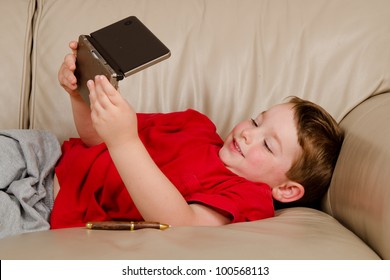 Couch Potato Concept Of Boy Playing Video Game While Resting On Sofa