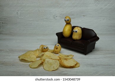 A Couch Potato, Showing A New Vegetable Family On A Sofa Chair With Scattered Fried Chips On A Wooden Plank Display Board.