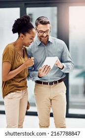 Could You Take A Look At Something Quick. Cropped Shot Of Two Businesspeople Looking At A Digital Tablet In Their Office.