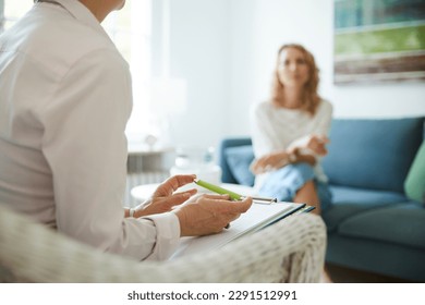 Counseling or therapy session with psychologist or doctor and client in office or practice room - Shutterstock ID 2291512991