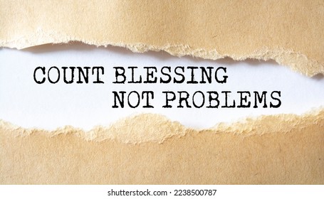 Count Blessing Not Problems word written under torn paper.