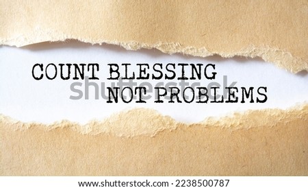 Count Blessing Not Problems word written under torn paper.