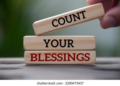 Count your blessings text on wooden blocks with blurred park background. Blessing concept.