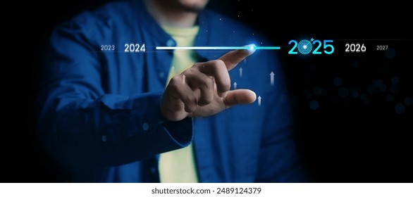 Countdown to 2025 concept. the taps a virtual download bar with a loading progress meter on New Year's Eve, turning the year 2024 to 2025.
