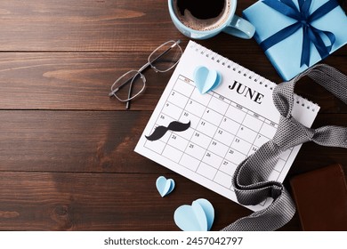 Countdown to Father's Day with this cozy setup featuring a June calendar, coffee, and rustic men's fashion accessories on a wooden background. Perfect for adding personal messages and wishes - Powered by Shutterstock