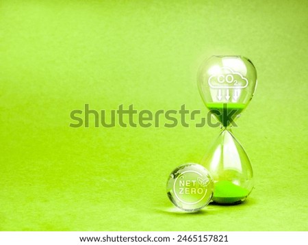Countdown to NET ZERO, carbon dioxide reduction, environment sustainability concept. Reduce CO2 emissions icon on hourglass and NET ZERO symbol on glass earth globe, green background with copy space..