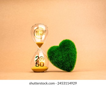 Countdown to NET ZERO emissions reduction, environment sustainability concept. NET ZERO icon and 2050 year number with target symbol on hourglass and green grass heart shape ball on brown background.