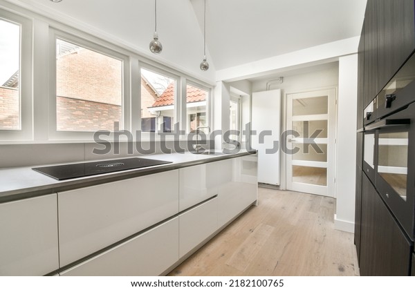 Counter with chairs dividing kitchen\
with modern furniture from dining area in contemporary\
flat