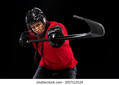 Counterattack. Professional female hockey player training in special uniform with helmet isolated over black background. Winning match. Concept of sport, action, movement, health. Copy space for ad