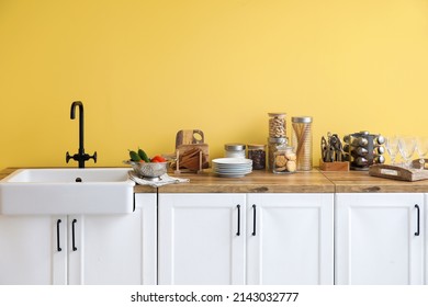 Counters With Sink, Food And Kitchen Utensils Near Yellow Wall