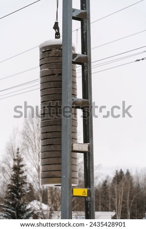 Counterweights for railway overhead electric wires in winter.