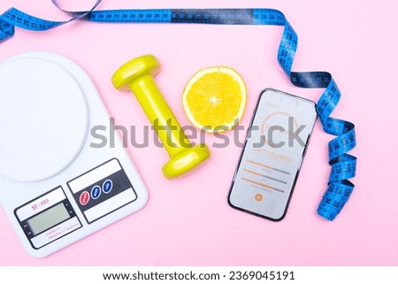 counting calories and macronutrients using an application on your phone. Effective diet. Flat lay photo showing a calorie-counting app next to a kitchen scale