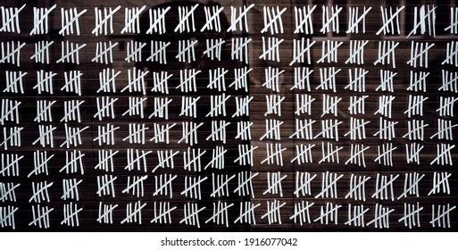 Counting stripes calendar. Handmade tally marks written on the wall by white chalk. Endless  pandemie lockdown, longtime prison, waiting for the summer, ancient counting methods concept.  - Shutterstock ID 1916077042