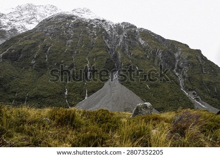 Countless ephemeral waterfalls cascade down the rugged cliffs and steeps slopes after rainy weather in Aoraki Mt Cook National Park.