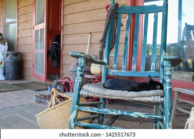 Country Farmhouse Front Porch With Antiques And Well Worn Shoes