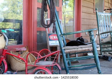 Country Farmhouse Front Porch With Antiques And Well Worn Shoes