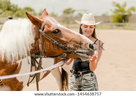 country girl feeding a horse on a ranch