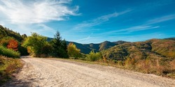 Country Gravel Road In Apuseni Mountains, Cluj Country, Romania. Sunny Autumn Scenery In Morning Light. Blue Sky With Clouds