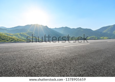 Country highway and green mountains natural landscape under the blue sky