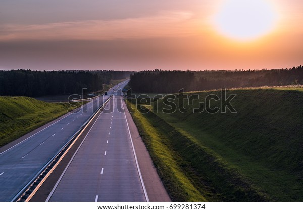 Country highway and sunset. Clear road great nature\
around. Horizontal view