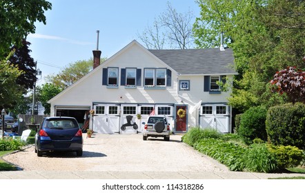 Country Home With Two Cars In Driveway Sunny Blue Sky Day