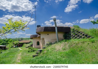 country house with oval walls covered with clay looks like a hobbit house in the countryside but with internet and light.