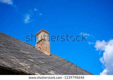 country house roof top with chimney on blue sky background