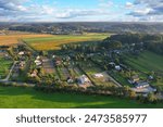 Country houses in countryside, aerial view. Rural landscape. Village wooden house in rural near farm field. Farmhouse in countryside. Suburban house in rural. Roofs of village houses in countryside. 