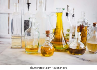 Country kitchen Still life. various bottles with raw olive oil with herbs and vinegar over on a marble rustic table. Vintage style. - Powered by Shutterstock