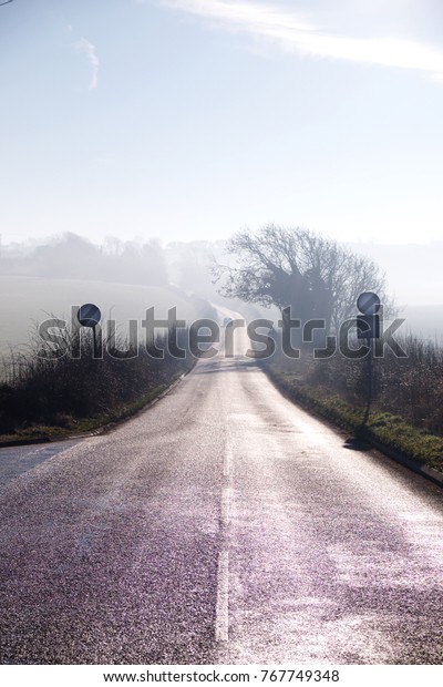 country lane winding into distance\
on misty morning, road sign, countryside, mist,\
sky
