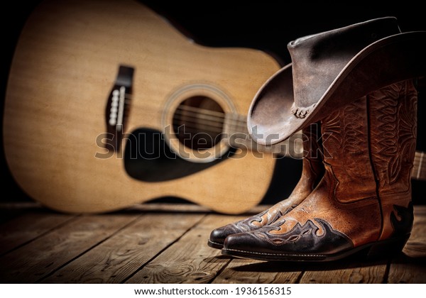 Country music festival live concert with\
acoustic guitar, cowboy hat and boots\
background