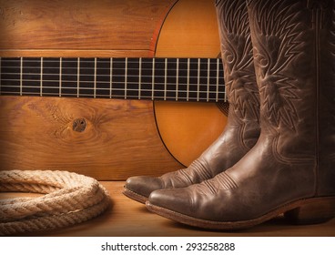 Country Music With Guitar And Cowboy Shoes On Wood Texture Background