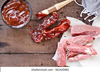 Country Ribs With Barbecue Sauce And Basting Brush Over A Rustic Table. 