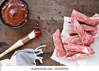 Country Ribs With Barbecue Sauce And Basting Brush Over A Rustic Table. 